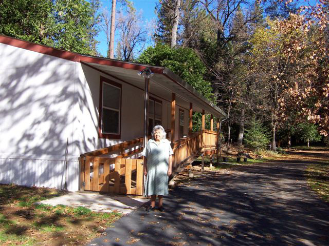 Elder Ruth Wilson in front of her new home with Ramp built by the Housing Department